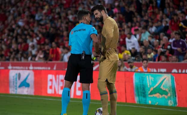 Piqué, comentando una acción con Gil Manzano, colegiado del Mallorca-Barça.  AFP