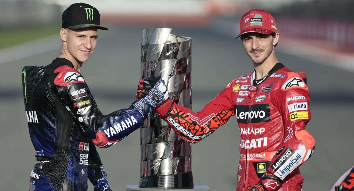 Fabio Quartararo y Pecco Bagnaia posan junto al trofeo que recoge los nombres de los campeones del mundo de MotoGP