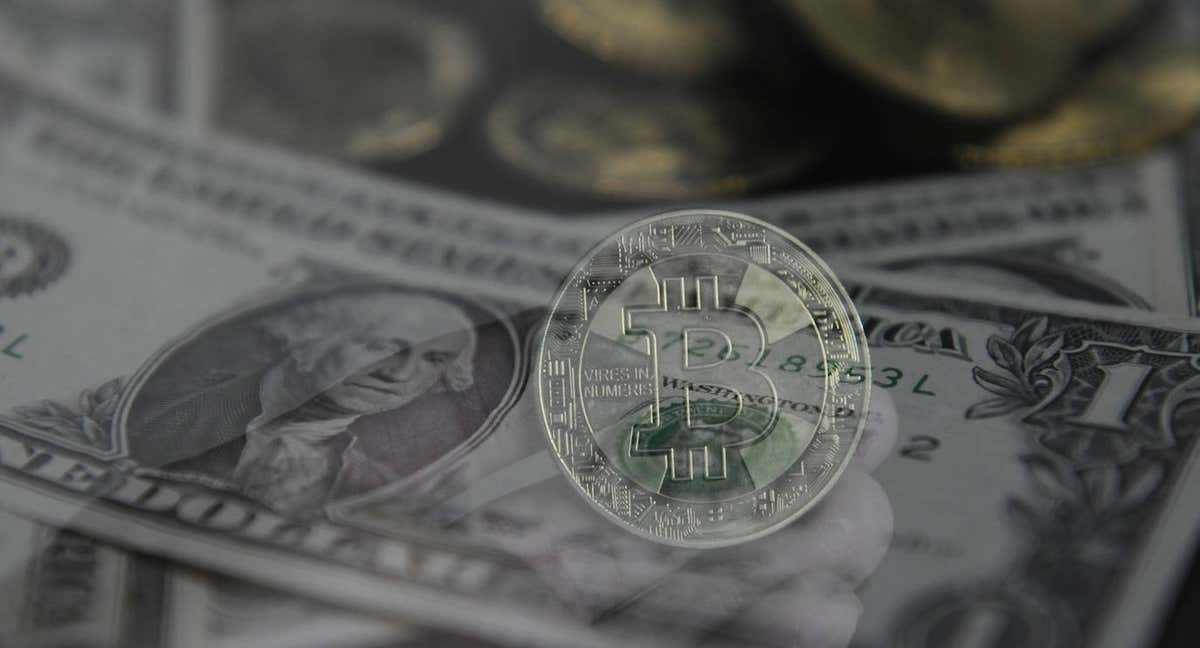 Una cryptomoneda con un dolar de fondo.