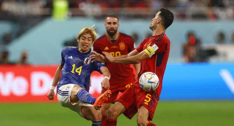 Junya Ito y Sergio Busquets disputándose el balón en el Japón - España del Mundial de Catar.