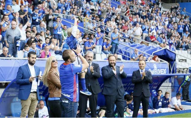 Sid Lowe levanta a su hijo Charlie Mateo, que realizó el saque de honor en el Carlos Tartiere.  REAL OVIEDO