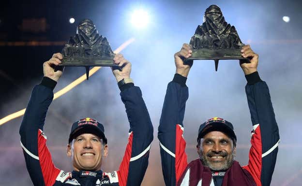 Mathieu Baumel y Al-Attiyah con los trofeos de ganadores del Dakar. AFP