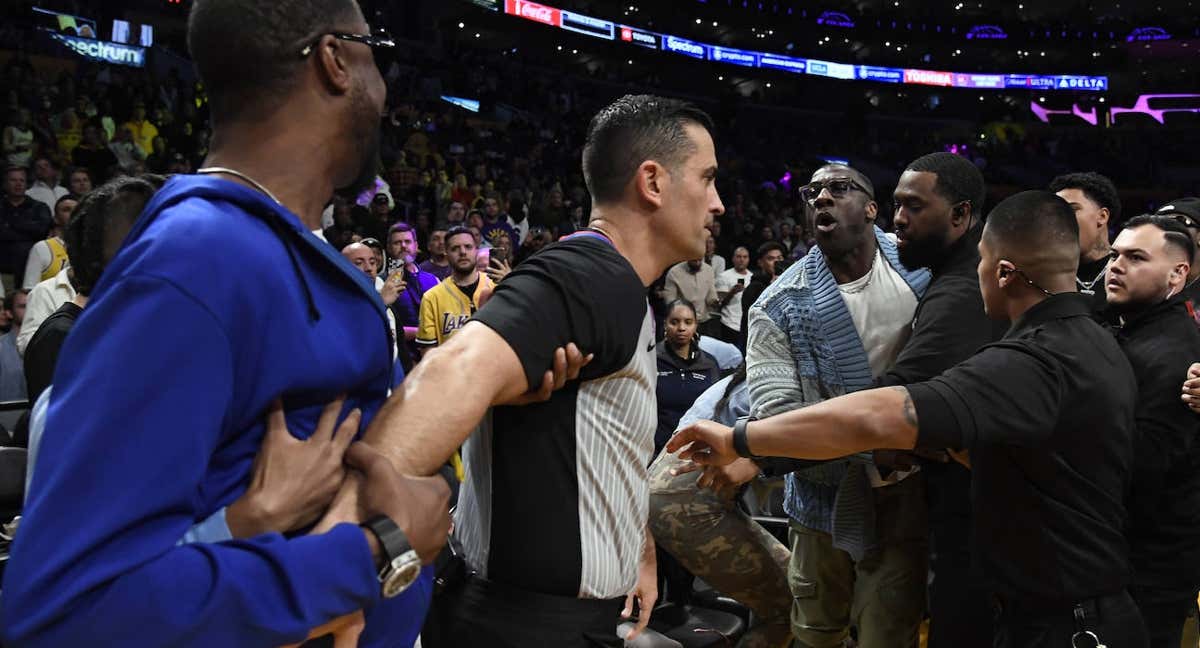 Varios miembros de seguridad trata de contener a Shannon Sharpe.