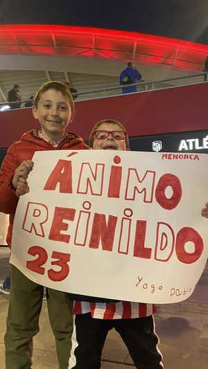Yago y Pablo, jóvenes aficionados del Atlético, con una pancarta.