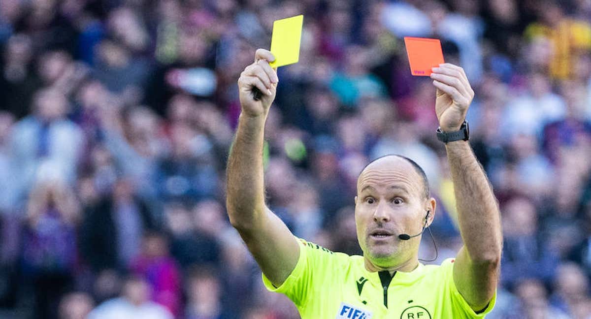 Mateu Lahoz enseña a la vez una amarilla y una roja, en el Barcelona-Espanyol, el pasado 31 de diciembre en el Spotify Camp Nou.