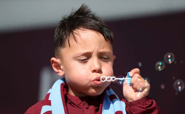 Un niño sopla burbujas en la previa de un partido del West Ham. GETTY
