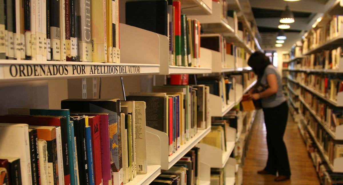 Mujer a lo lejos ojea los libros de la biblioteca de Segovia./QUAY: ANTONIO TANARRO