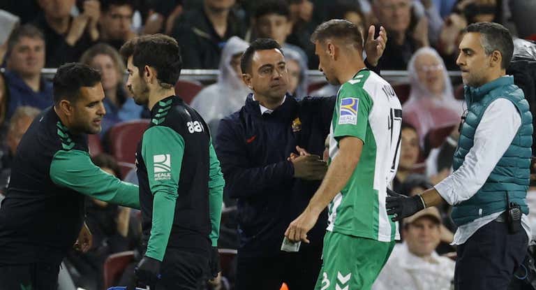 Joaquín le da explicaciones a Xavi mientras se retira del terreno de juego.