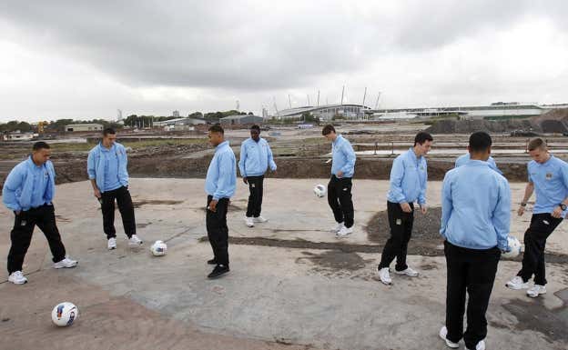 Canteranos del Manchester City juegan sobre las obras de la ciudad deportiva en 2011. Getty