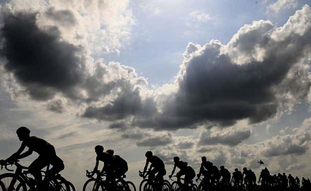 El pelotón del Giro de Italia 2023, oscuro, bajo un cielo de nubes y claros.  RCS / LA PRESSE
