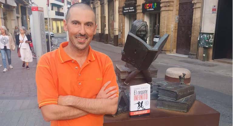 Daniel Pinilla posa en el centro de Sevilla junto a su nuevo libro.