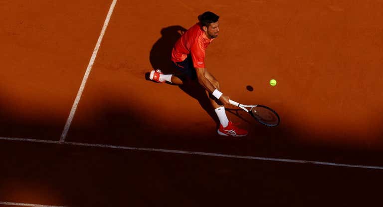 Novak Djokovic intenta llegar a una dejada durante su partido ante Khachanov en los cuartos de final.