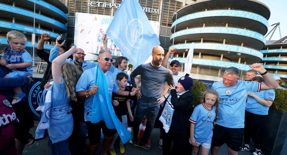 Aficionados del Manchester City con una figura de Guardiola en los aledaños del Etihad Stadium. /GETTY