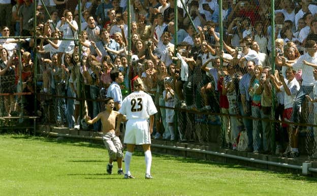 El pequeño Alfonso López se salta el cordón de seguridad y va a abrazar a Beckham.  GETTY