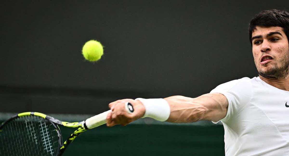 Carlos Alcaraz pelea una pelota en un partido de Wimbledon./AFP