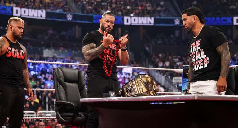 Solo Sikoa, Roman Reigns y Jey Uso, durante la firma del contrato de su combate en SummerSlam.