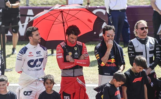 Carlos Sainz, entre Ricciardo y Pérez, en la preparrilla del GP de Hungría.  EFE
