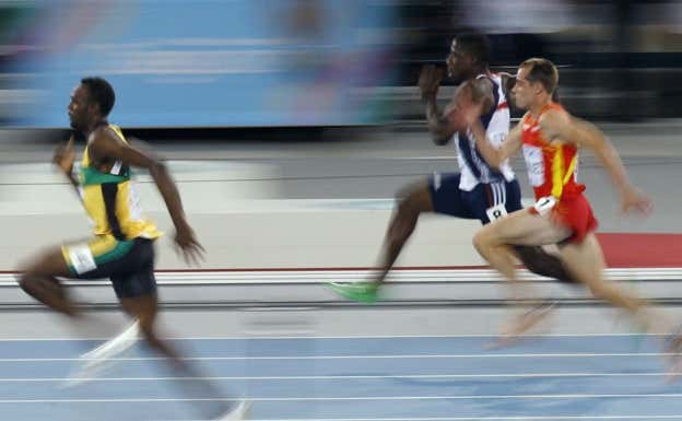 Ángel David Rodríguez (derecha) corre en los Mundiales de Daegu ante Usain Bolt (izquierda). REUTERS