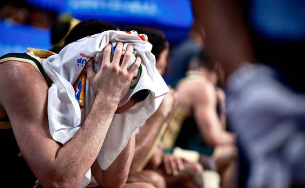 Josh Giddey se lamenta de la eliminación en el banquillo.  FIBA