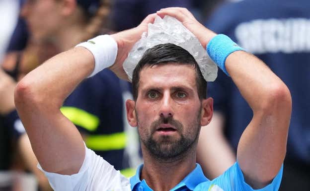 Novak Djokovic se pone una bolsa de hielo en la cabeza.  Reuters