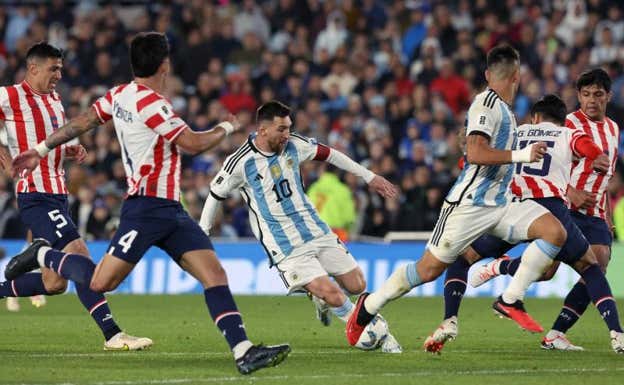 Leo Messi, rodeado de paraguayos, en la segunda mitad del encuentro.  AFP