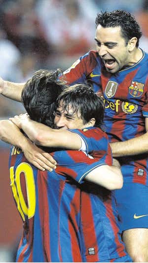 Bojan se abraza a Messi y Xavi festejando un gol.  EFE