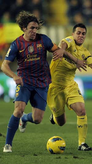 Joselu pelea por un balón con Carles Puyol.  AFP