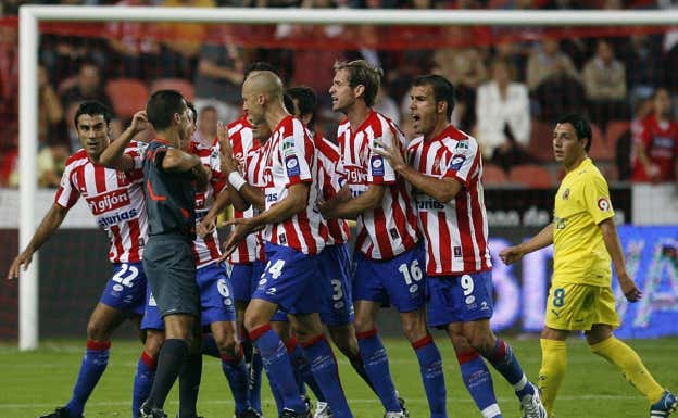 Paradas Romero rodeado de jugadores del Sporting de Gijón.  Joaquín Bilbao