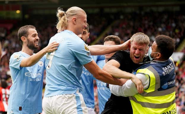 Un aficionado del Manchester City salta al césped a celebrar un gol con Haaland. Getty Images