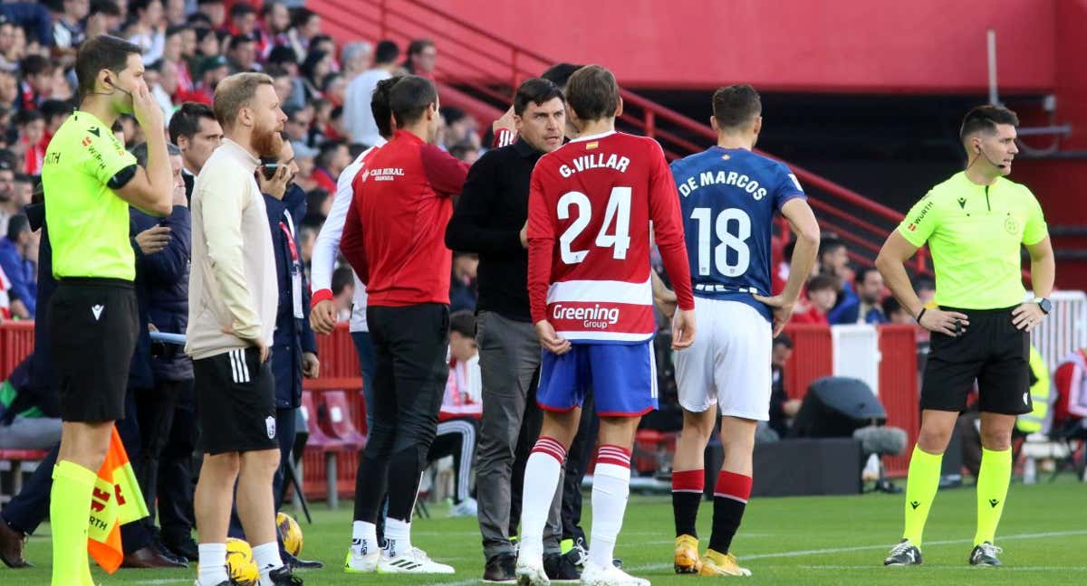 Varios jugadores, cuerpo técnico y el colegiado Ortiz Arias esperan durante la parada del juego./EFE