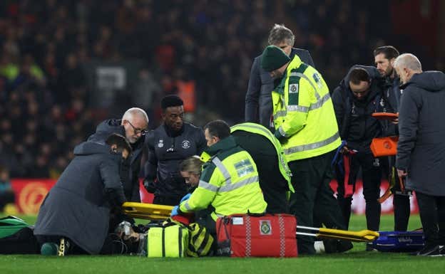 Los médicos atienden al capitán del Luton sobre el césped.  REUTERS