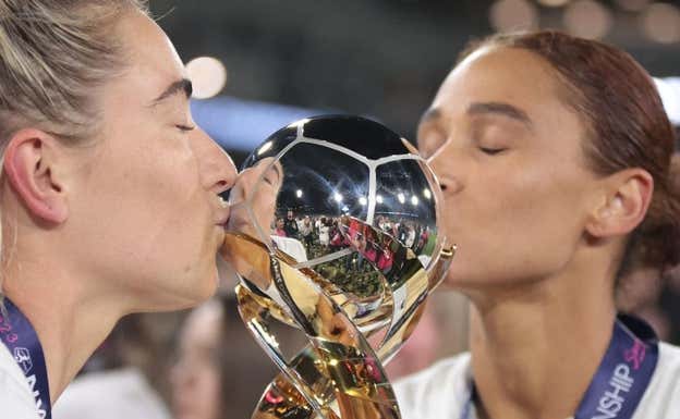 Kristie Mewis y Lynn Williams besando el trofeo.  NWSL