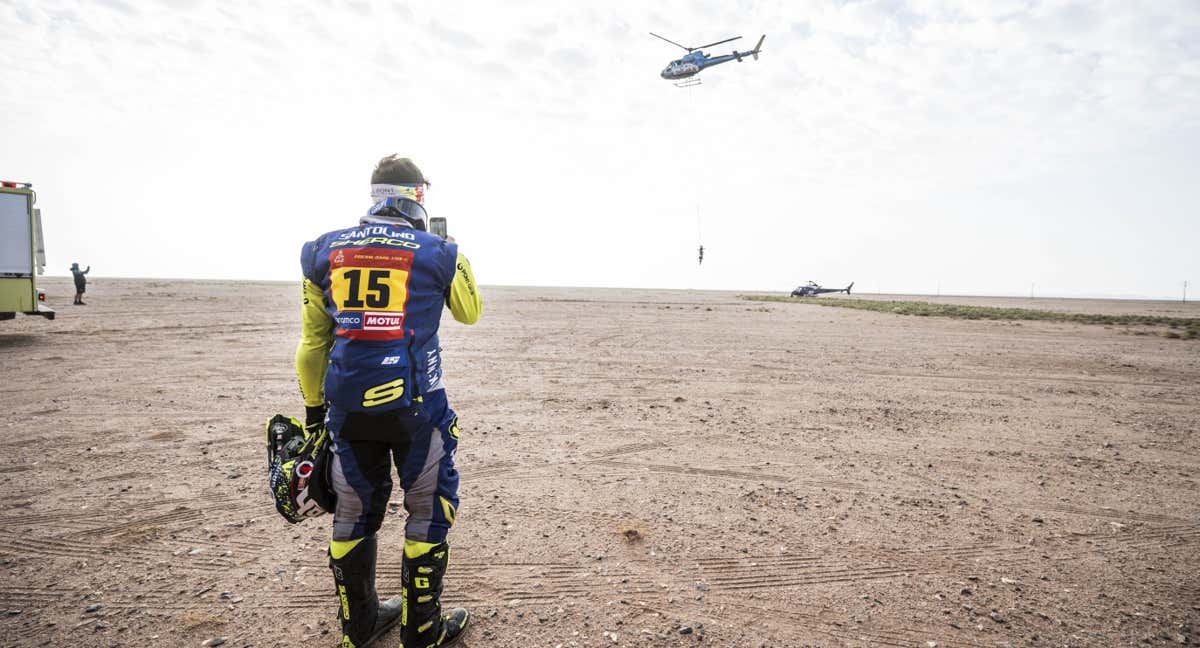 Lorenzo Santolino hace una foto a su moto mientras se la lleva el helicóptero. /A.S.O./Charly Lopez