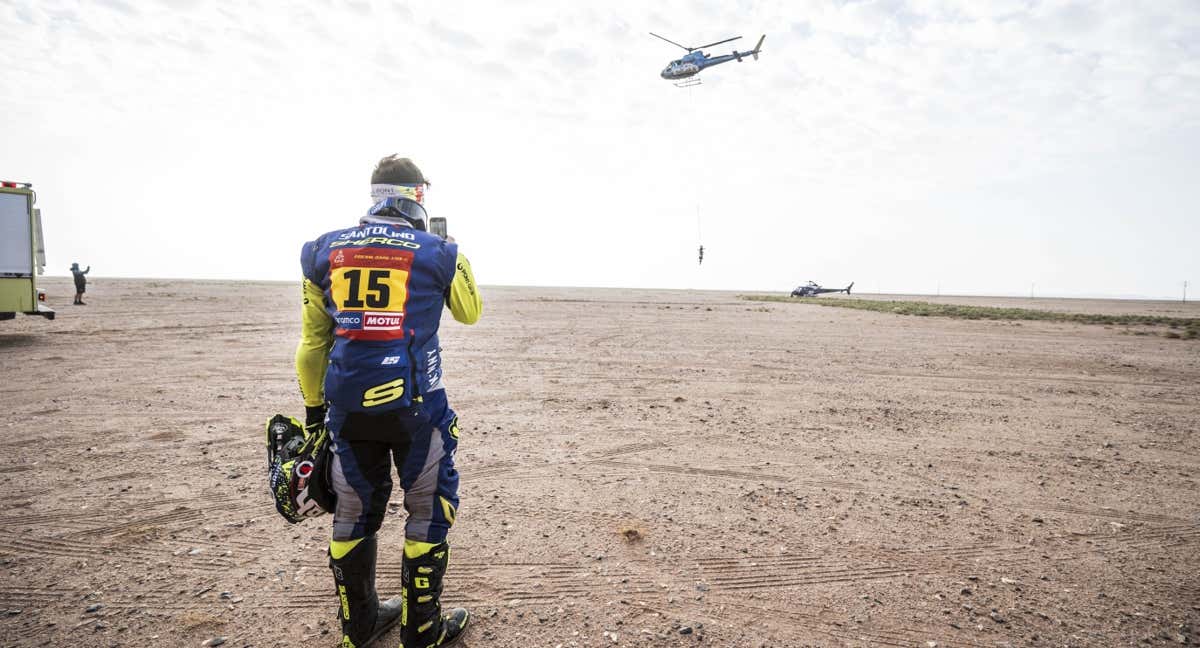 Lorenzo Santolino hace una foto a su moto mientras se la lleva el helicóptero.