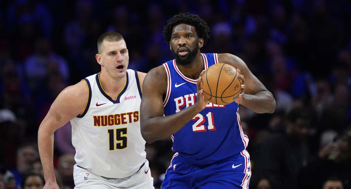 Joel Embiid retiene el balón ante la defensa de Nikola Jokic
