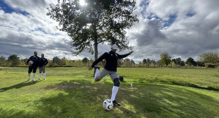Un hombre golpea a la pelota durante un partido de footgolf.