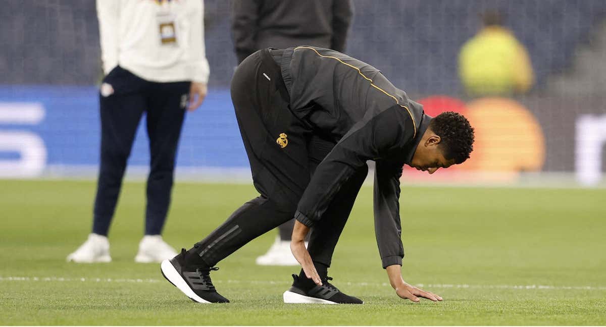 Bellingham tocando el césped del Bernabéu./Reuters