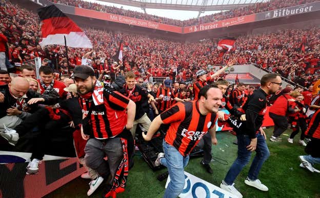 Los seguidores del Bayer saltan al terreno de juego.  REUTERS