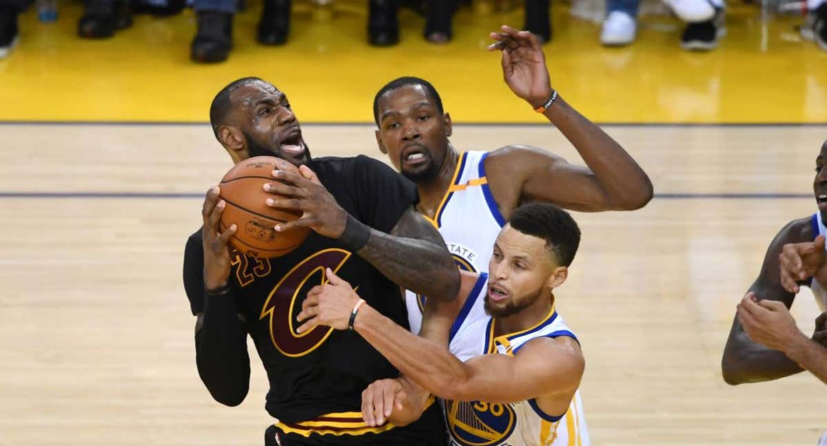 LeBron James defiende el balón ante la presión de Curry y Durant en un partido de las Finales NBA 2017./Getty