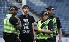 “Tarjeta roja a Israel”: un manifestante por Palestina atrasa el partido ante Escocia y se ata al poste... pese a ser a puerta cerrada