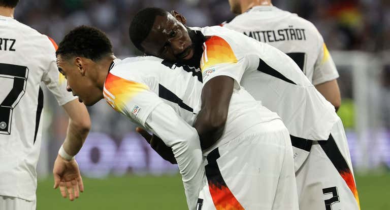 Rüdiger abraza a Musiala durante el partido.