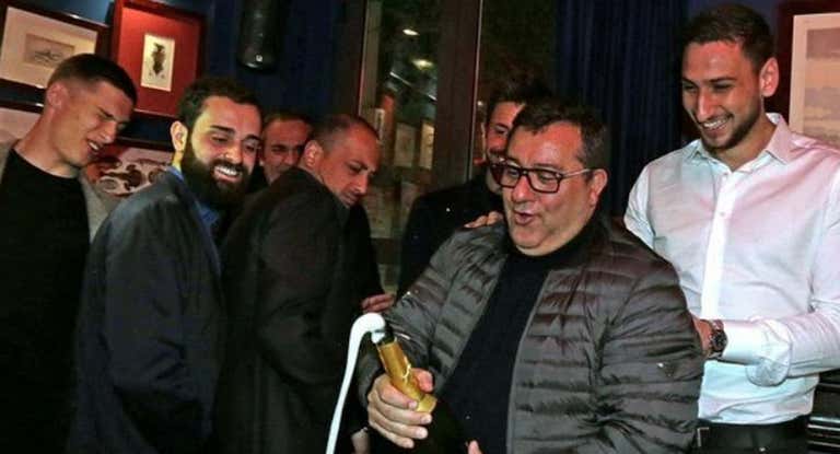 Enzo Raiola, de espaldas, mira cómo su tío descorcha una botella con Donarumma al fondo.