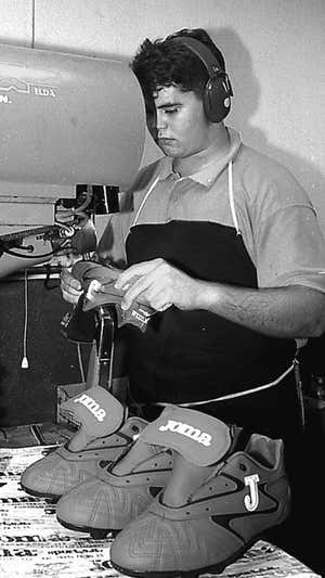 Imagen de archivo de un trabajador fabricando unas zapatillas.  Joma