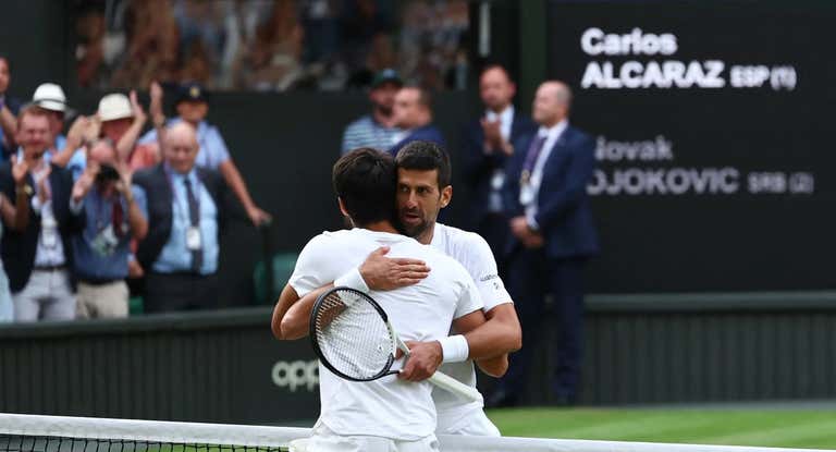 Djokovic y Alcaraz se abrazan en la red de Wimbledon.