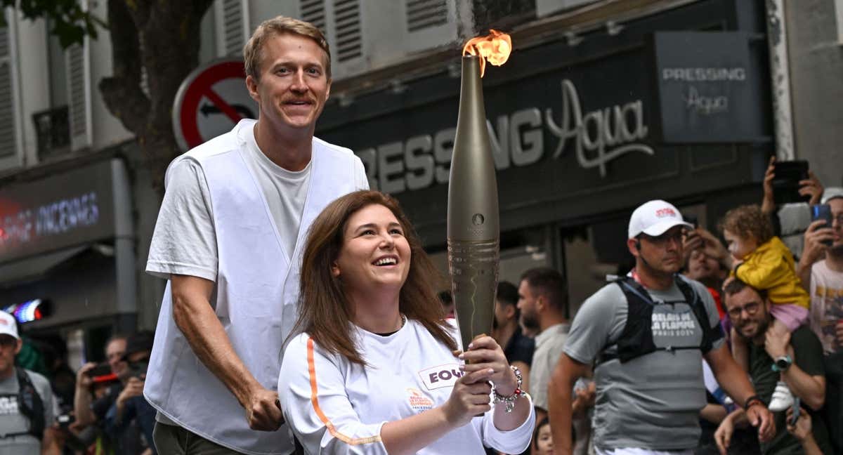 Christina Assi y Dylan Collins llevan la antorcha olímpica./AFP