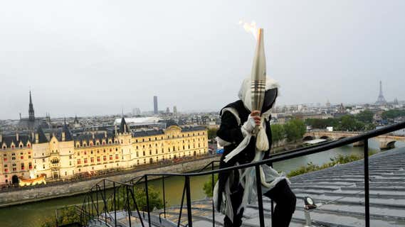 El personaje enmascarado porta la antorcha en la ceremonia de inauguración de los Juegos. /REUTERS