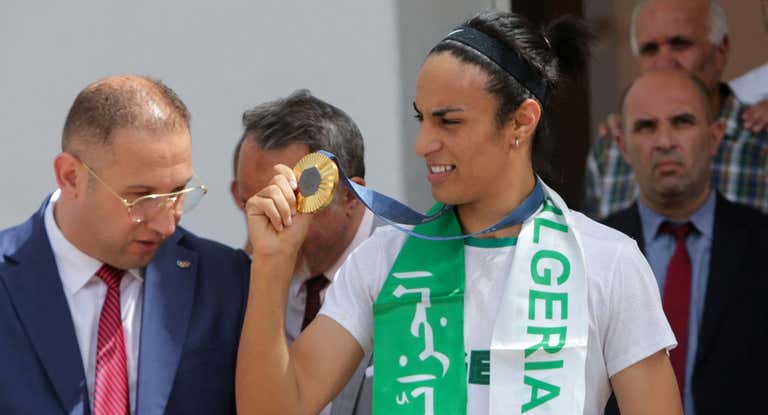 Imane Khelif enseña su medalla de oro al llegar a Argelia.