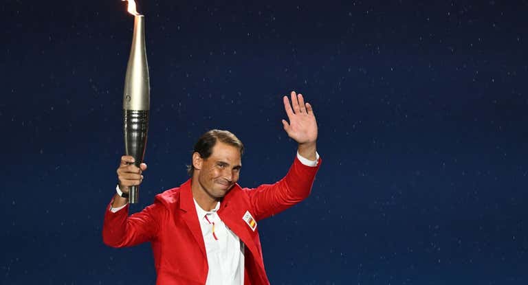 Rafael Nadal sostiene la antorcha olímpica durante la ceremonia inaugural de los Juegos de París 2024.