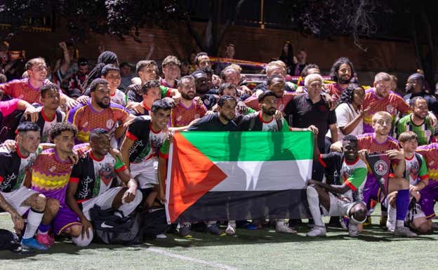 Foto de familia con la bandera palestina del equipo de Dader y el Clapton CFC inglés.  Relevo/Pablo Muñoz