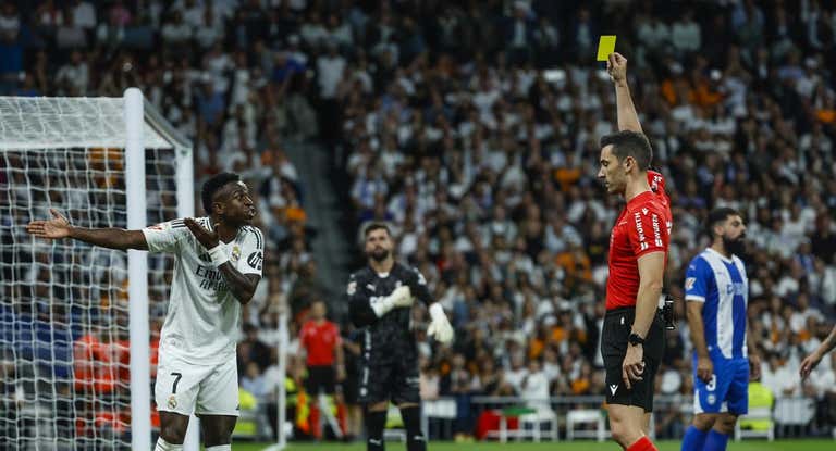 Muñiz Ruiz le saca una amarilla a Vinicius durante el partido con el Alavés.